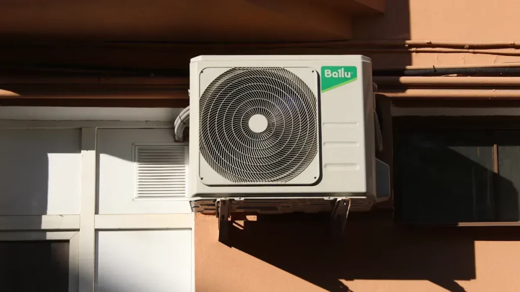 Outdoor air conditioning unit mounted beside a window