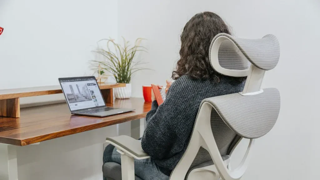 Person seated in an ergonomic chair at a desk