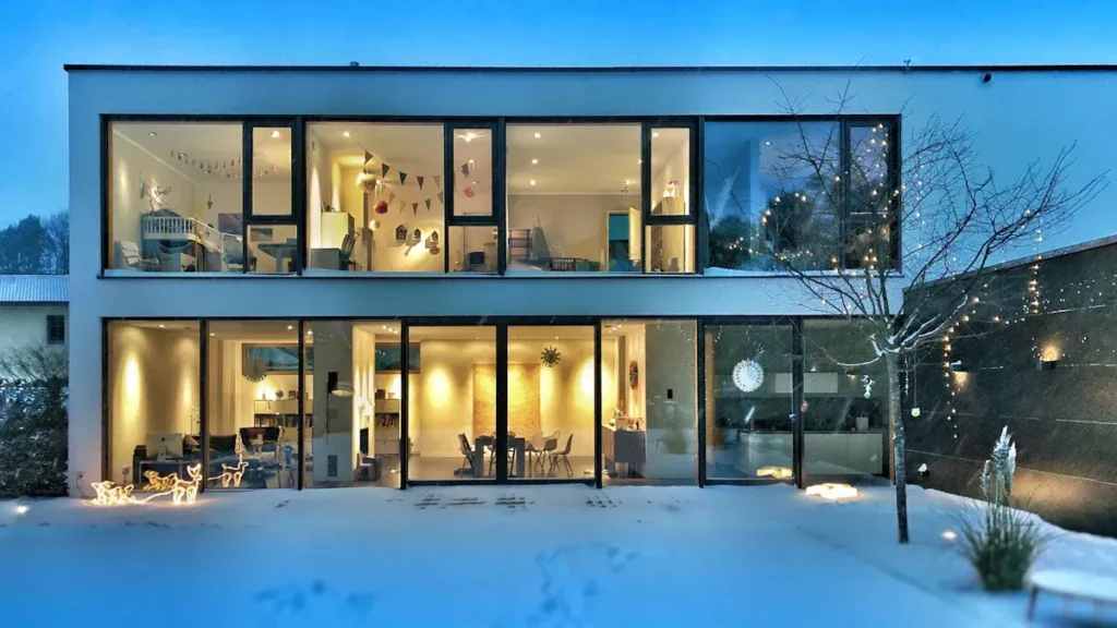 Modern two story house with large glazed windows at dusk