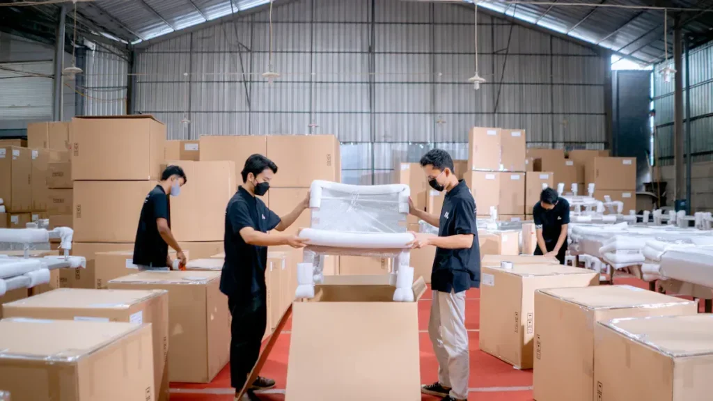 Workers packing cabinet components in a warehouse