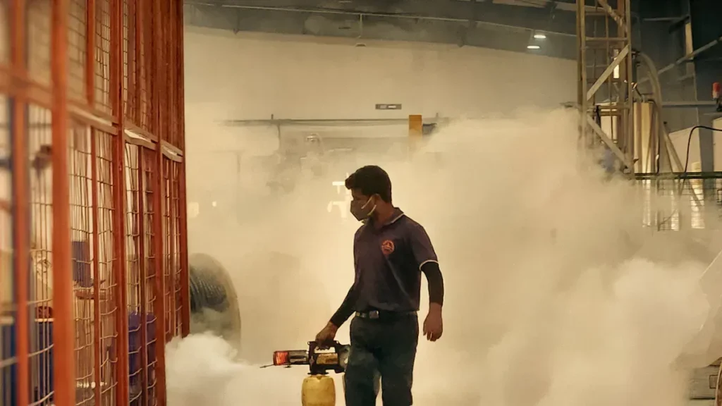 Person using fire safety equipment in a smoky training area