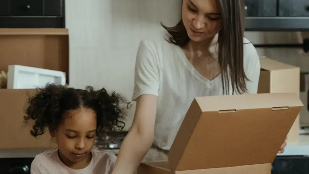 Adult and child unpacking a cardboard box