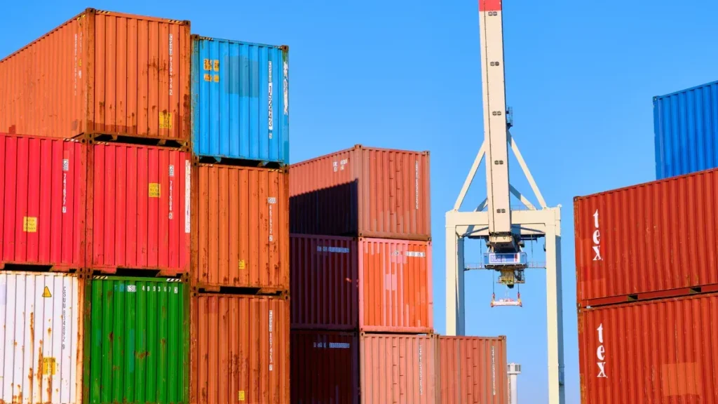Shipping containers stacked beside a port crane