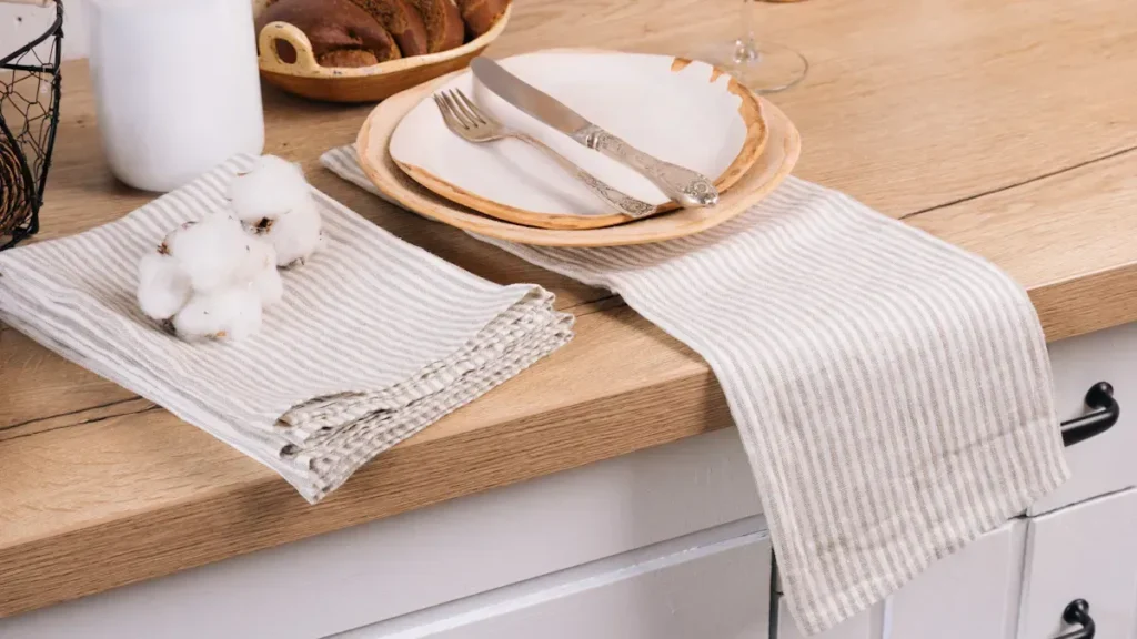 Wooden countertop with tableware and folded linen