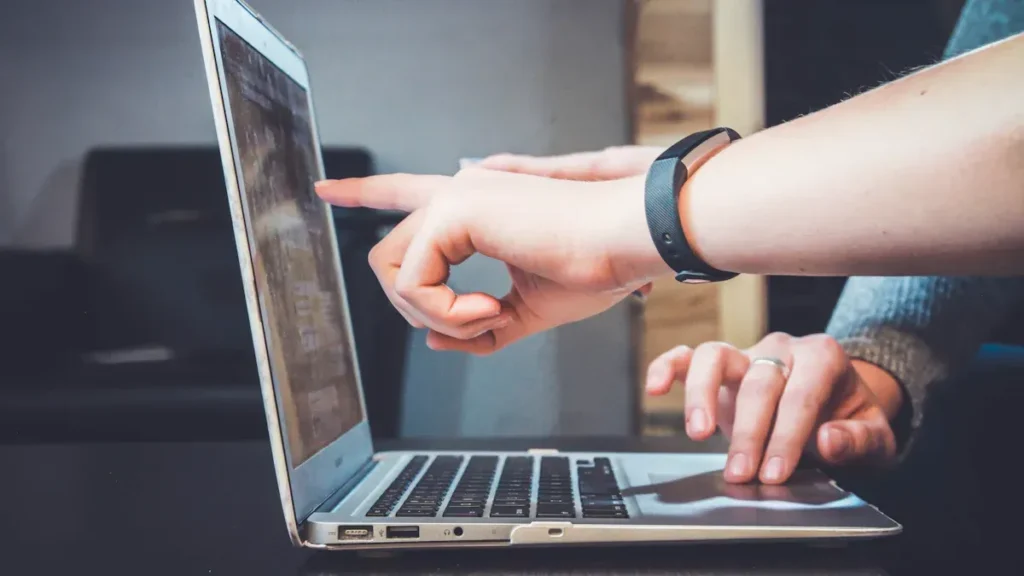 Two people reviewing information on a laptop