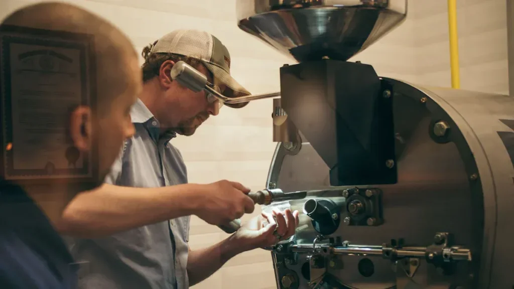 Worker operating coffee equipment behind a counter