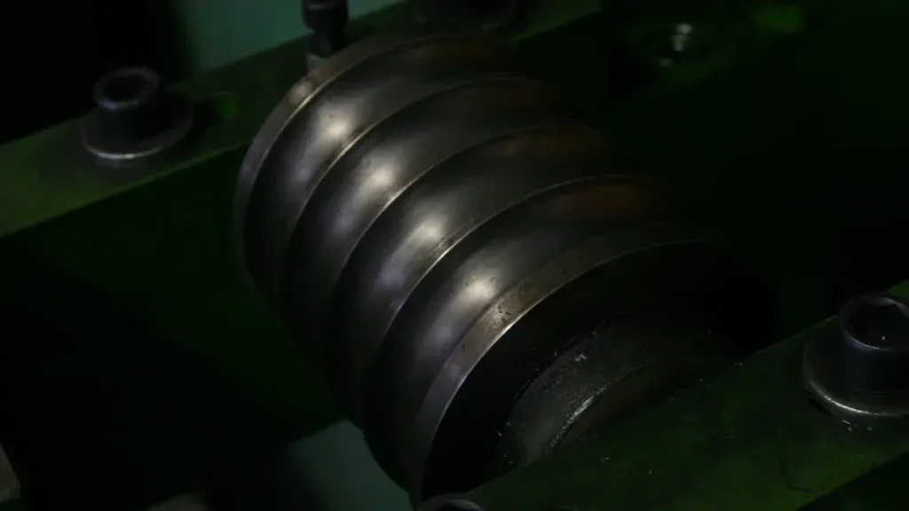 Close up of a dark grooved metal roller component