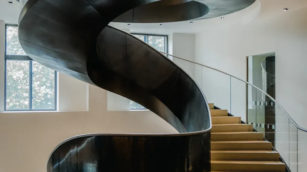 Dark curved spiral staircase with wooden treads