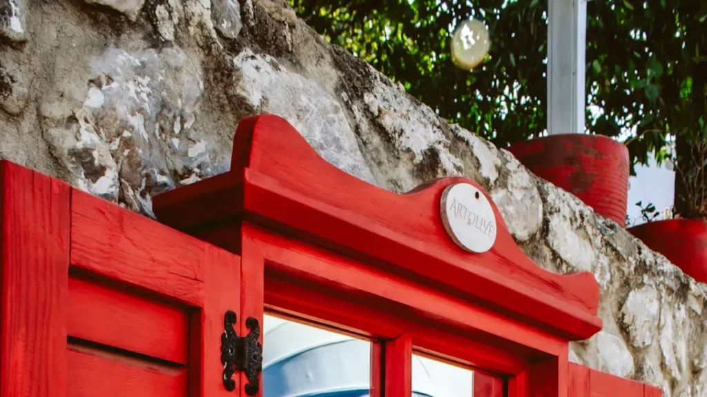 Red painted door beneath a stone wall