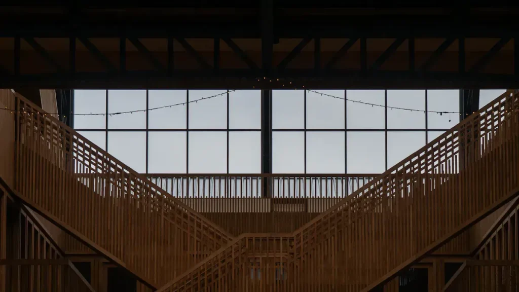 Wooden interior structure beneath a large glazed wall