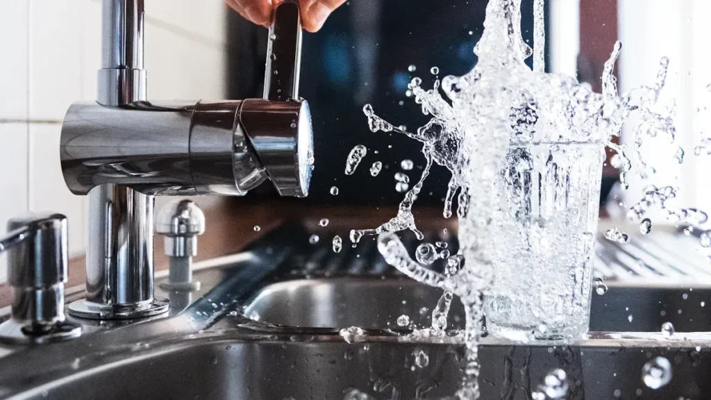 Running faucet splashing water into a sink